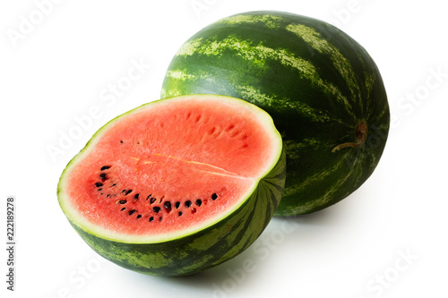 Half watermelon with seeds next to whole watermelon isolated on white.