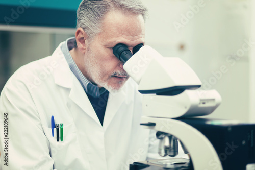 Scientist conducting research looking through microscope