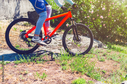 A cyclist on an orange bike is driving off-road
