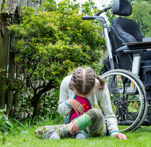 Disability a disabled child relaxing in the garden photo