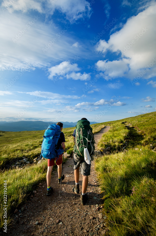 Tourist friends on a top of mountains in a Scottish Highlands. Scotland nature. Tourist people enjoy a moment in a nature.
 Tourists favourites place in Scotland - Isle of Skye.