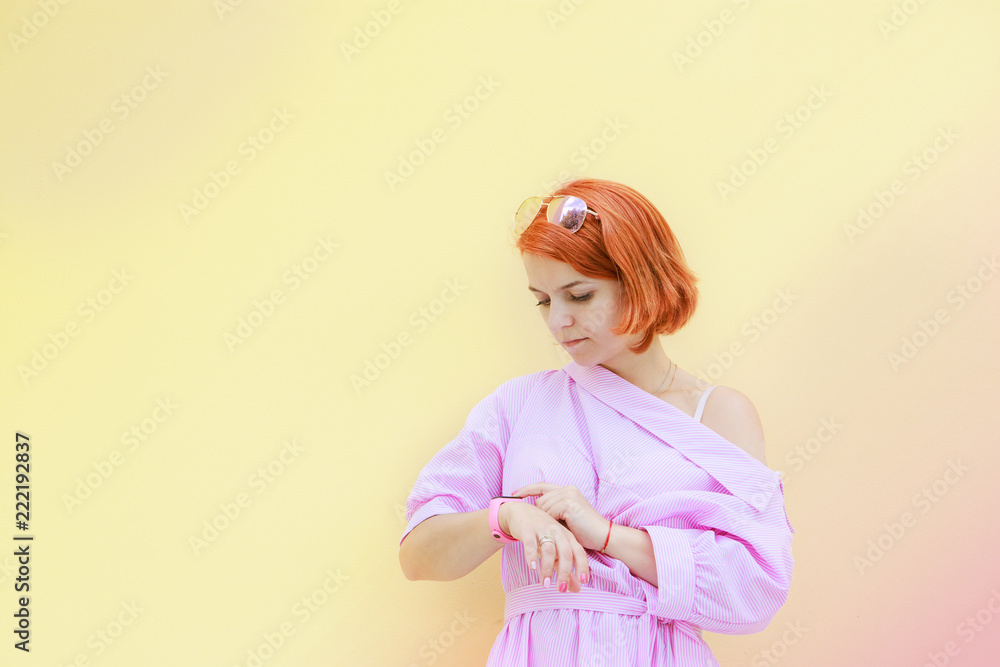 cute redhead girl looking at her watch and waiting for someone late waiting
