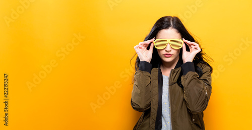 Fashionable woman with attitude in bomber jacket on a golden yellow background photo