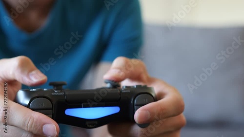 Young Man Playing a Video Game on a Couch, Close Up of the Controller photo