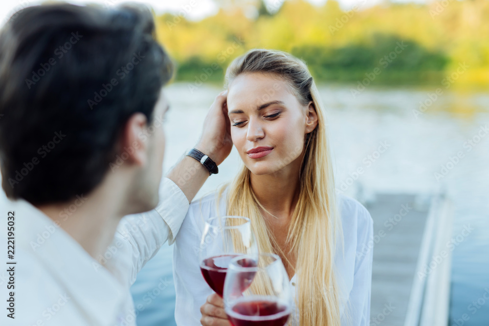 Caring boyfriend. Nice caring man touching his girlfriends hair while  expressing his love to her Stock Photo | Adobe Stock