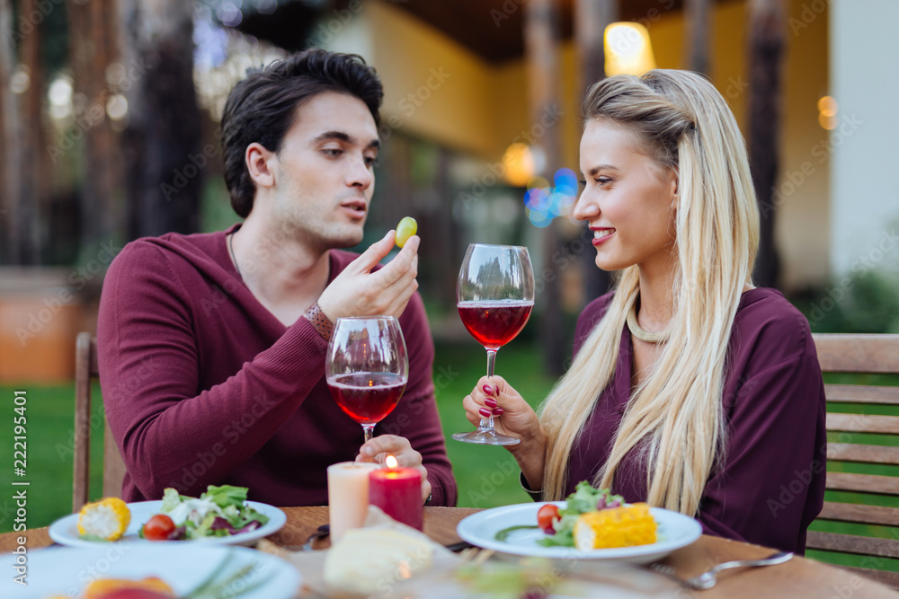 Romantic celebration. Delighted positive couple sitting together in the restaurant while drinking wine