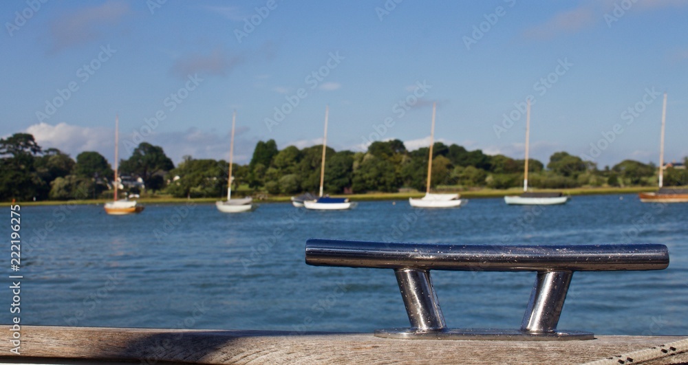 Line of Moored Sailboats in background with a Cleat in Foreground