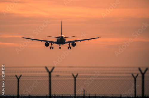Airplane landing at sunset © robertdering