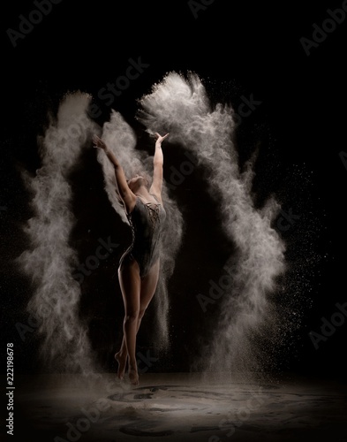 Fototapeta Naklejka Na Ścianę i Meble -  Slim blonde jumping in white powder cloud