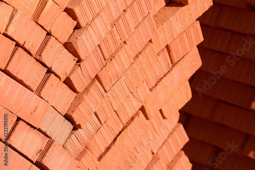 Pile of stacked new red bricks. Clay brick blocks ready for construction. 