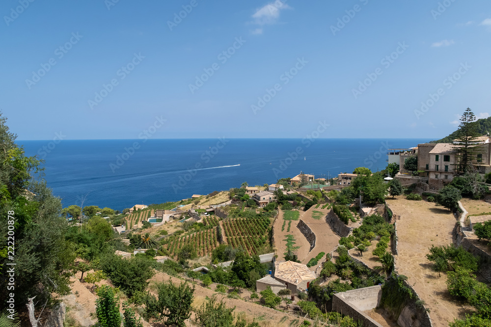 historic village of Banyalbufar on Mallorca, Spain against blue sky and sea on sunny summer day
