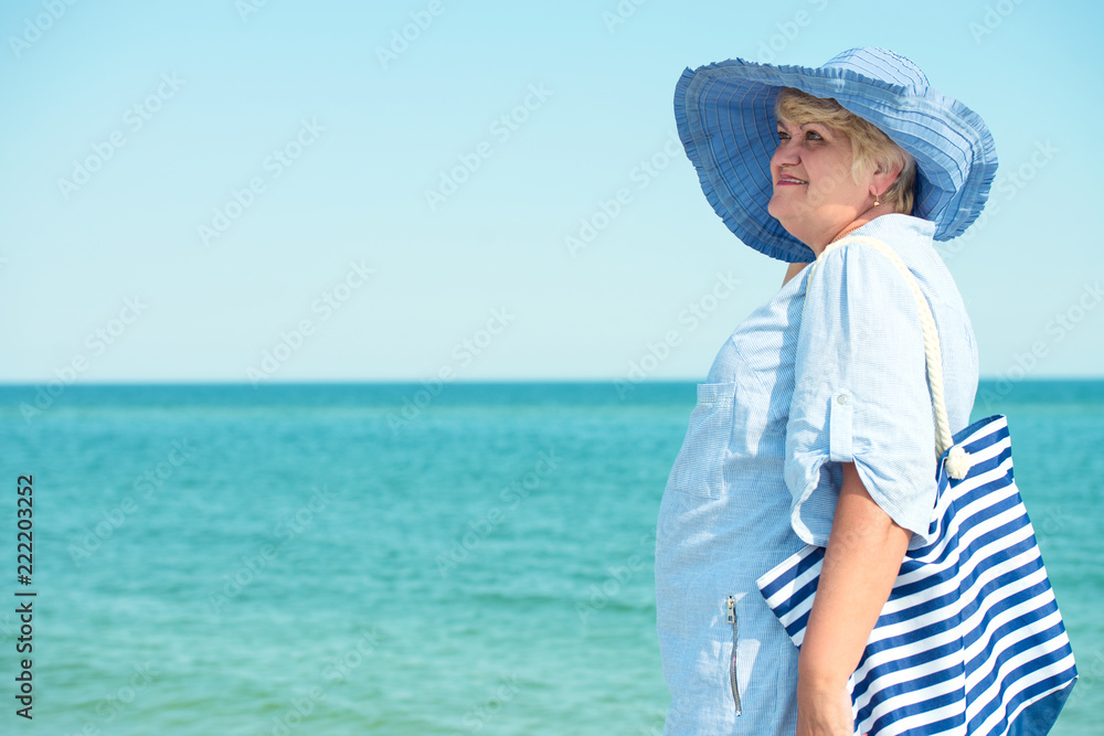 An elderly woman in a hat rest on the sea. Summer vacation. An elderly woman in a hat rest on the sea. Summer vacation.