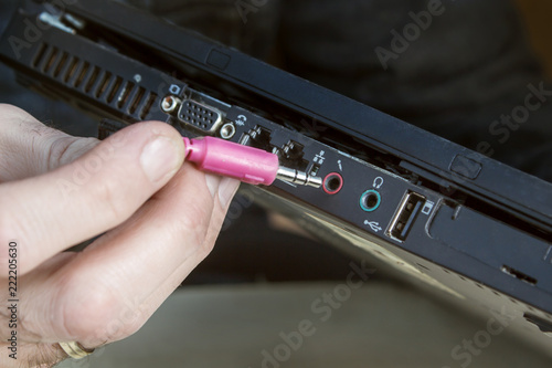 Podłączanie czerwonej wtyczki cinch do gniazda mikrofonu w laptopie.