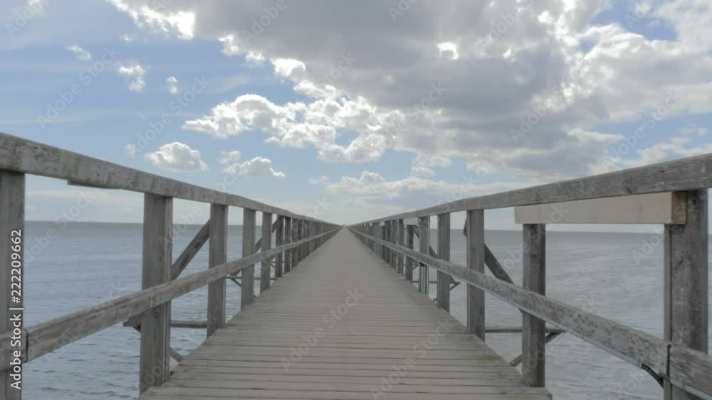 camera movement along the wooden pier that is endless a summer day with blue sky and white clouds camera movement along the wooden pier that is endless a summer day with blue sky and white clouds