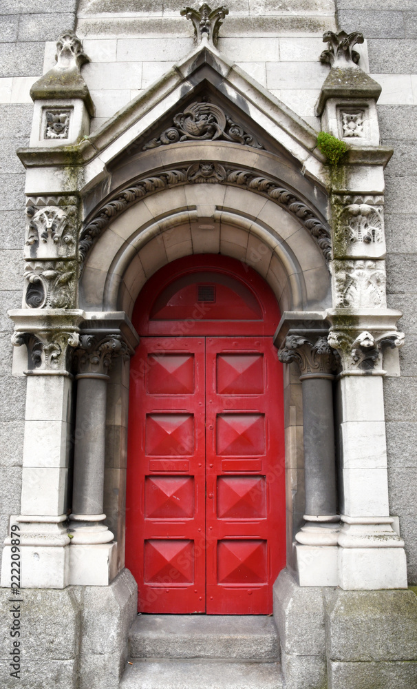 Wundervolle reich verzierte, rote Haustür mit Säulen und Reliefs