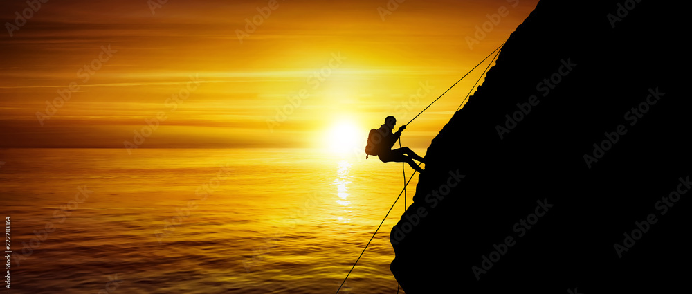Silhouette of a beautiful athletic woman climbing a steep rock above the sea - obrazy, fototapety, plakaty 