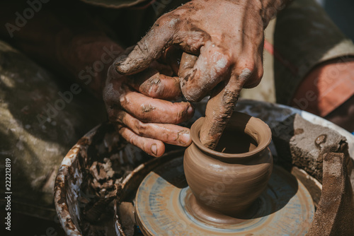 Master hands makes a pot of clay. Master class is held in nature, close-up