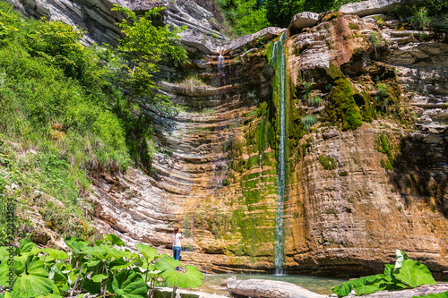 Foto Woman near waterfall in mountain of Caucasus