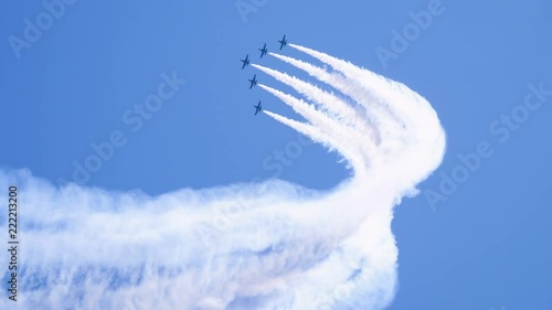 Five airplanes flying on the background of blue sky and leaving a condensation trail. 4K