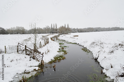 River in a snow covered field photo