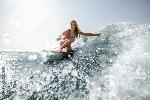 Obraz Blondynki dziewczyny pozycja na wakeboard i patrzeć kamerę