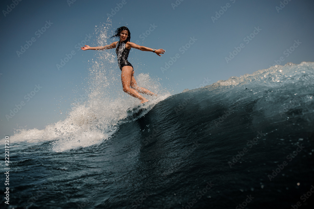 Attractive girl riding on the wakeboard on the lake
