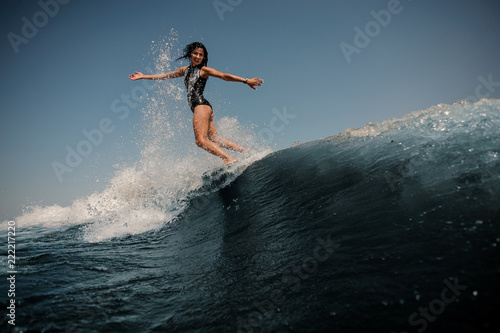 Attractive girl riding on the wakeboard on the lake