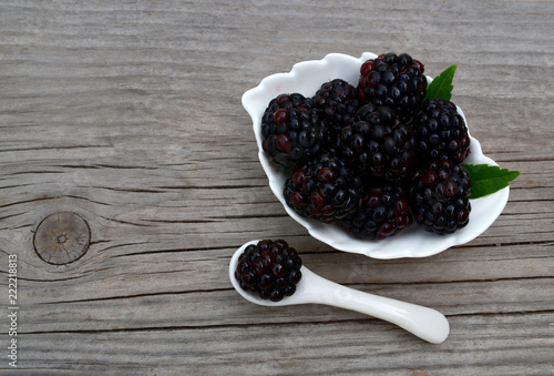 Freshly picked organic blackberries in a white bowl on old wooden table.Healthy eating,
vegan food or diet concept.Selective focus.