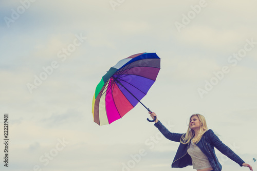 Woman holding colorful umbrella on beach