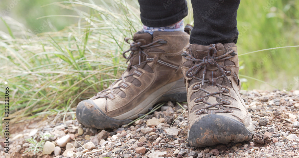 Tight shot of persons hiking shoes standing on earthy trail outdoors