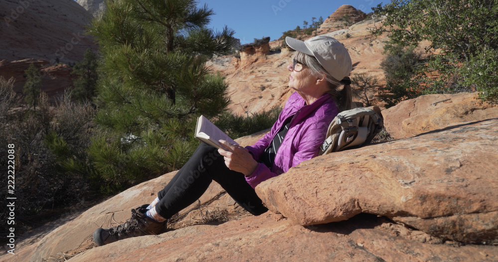 Serene portrait of healthy senior woman enjoying nature and reading a book Serene portrait of healthy senior woman enjoying nature and reading a book