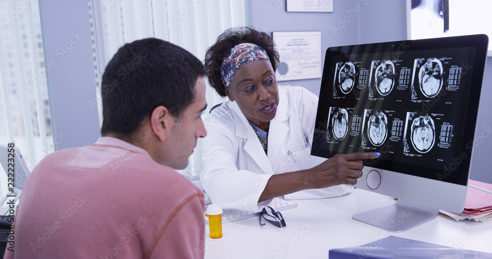 Φωτογραφία Close up of senior African doctor explaining to young patient his ct-scans of cranium