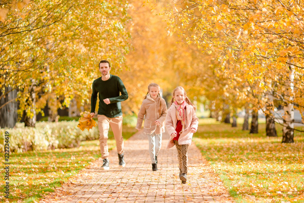 Fototapeta premium Family of dad and kids on beautiful autumn day in the park