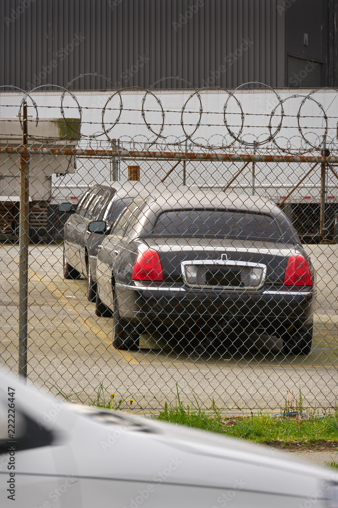 Limos Behind Razor Wire. Limousines behind razor wire in a rough part ...