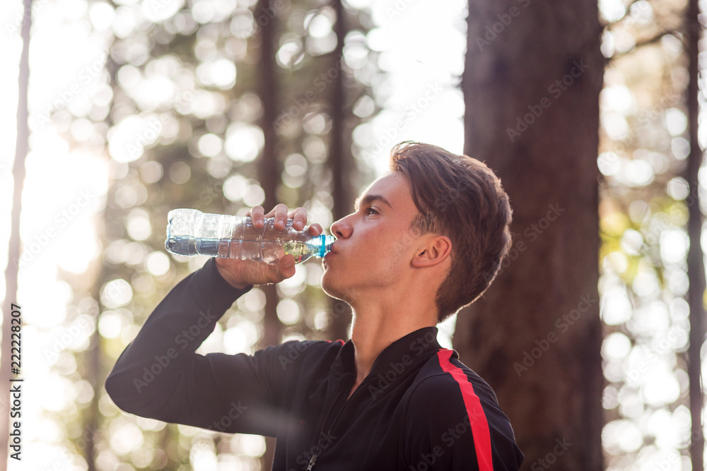 Young man drinking water after training outdoor.Sport man drinking water Young man drinking water after training outdoor.Sport man drinking water