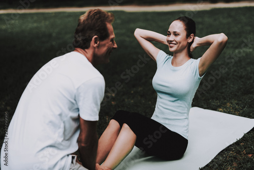 Young Couple in Sportswear Doing Yoga in Park