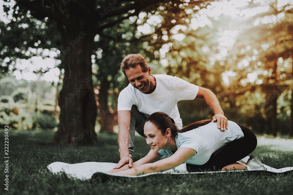 Young Couple in Sportswear Doing Exercises in Park Young Couple in Sportswear Doing Exercises in Park