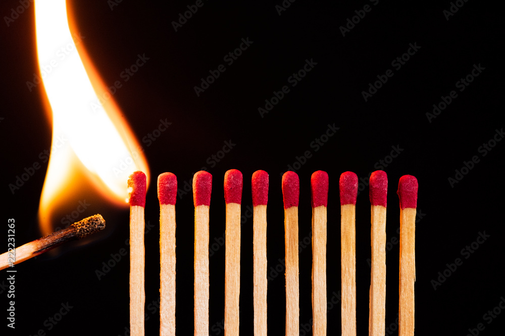 Lit match next to a row of unlit matches. The Passion of One Ignites New  Ideas, Change in Others. Stock Photo
