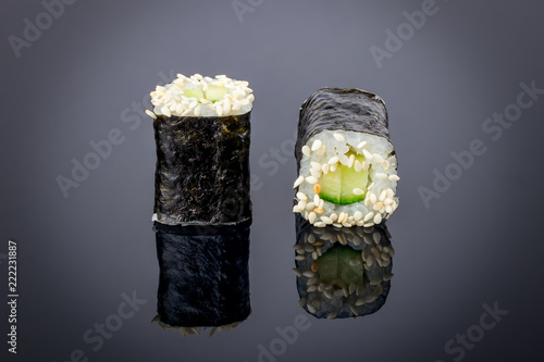 cucumber maki on black background with reflection