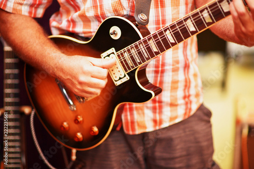 A closeup of a man playing an electric guitar. 