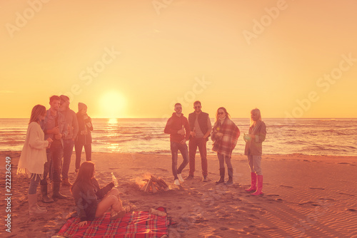 Friends having fun at beach on autumn day