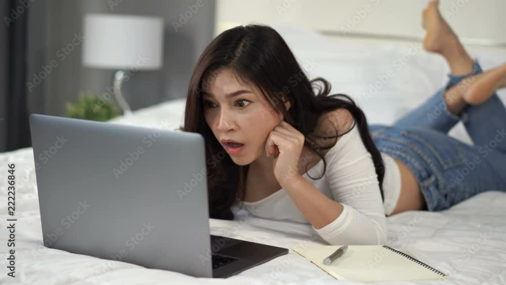 surprised woman using a laptop computer on bed surprised woman using a laptop computer on bed