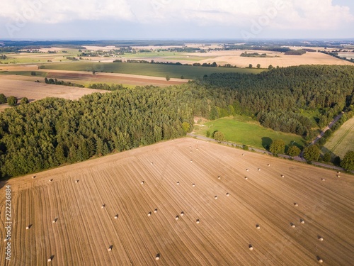 Aerial: stubble field with straw bales at late summer