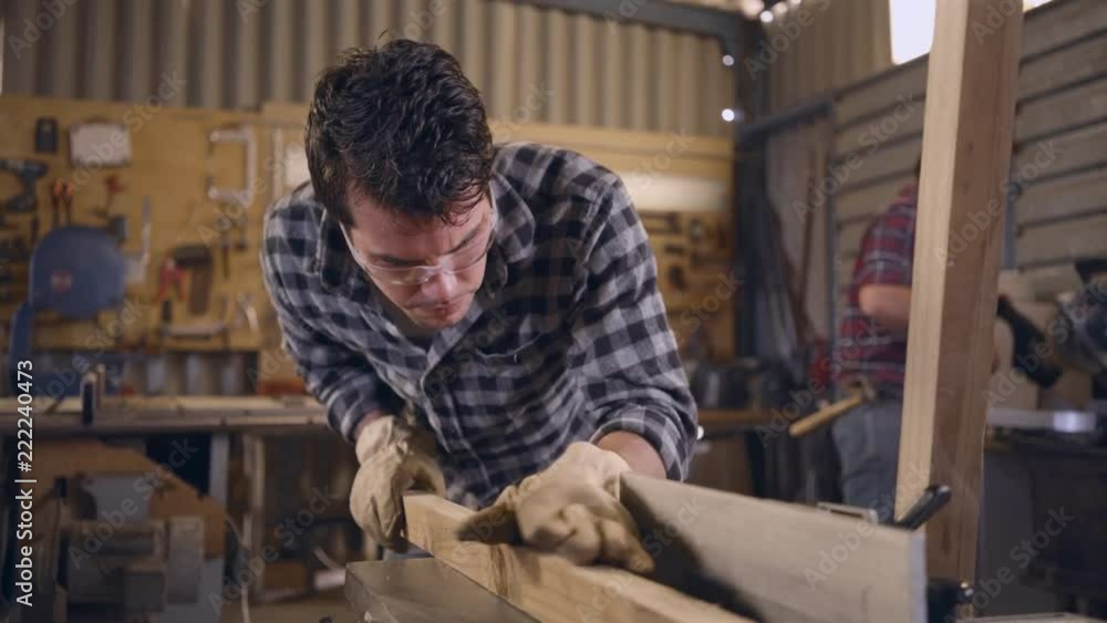 Young white male carpenter inspecting wood Young white male carpenter inspecting wood