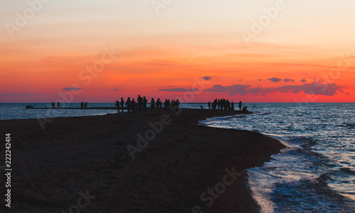 Beautiful seascape with people watching the sunset over the sea © Maksim Kostenko