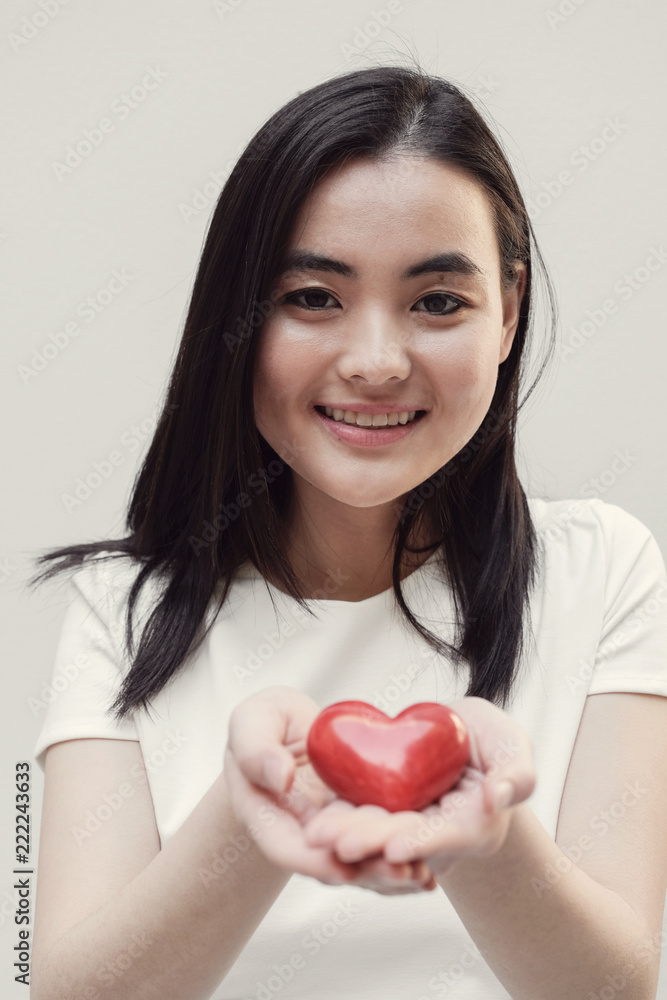 Asian young woman holding red heart, health insurance, donation concept Asian young woman holding red heart, health insurance, donation concept