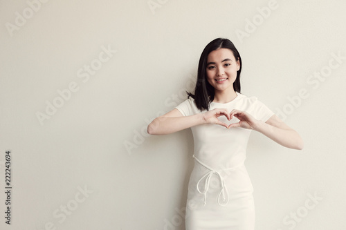 Happy Asian young woman making her hands in heart shape