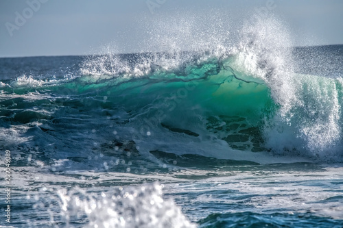 Turquoise blue wave breaking and spray
