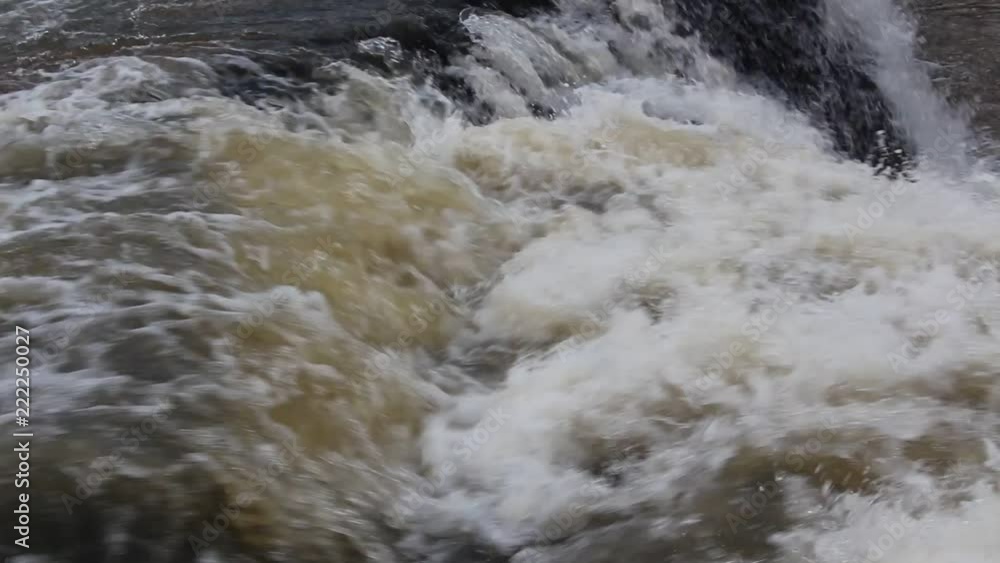 Torrential flow of water in the rapids during the rainy season, creating white bubbling waves and strong water current Torrential flow of water in the rapids during the rainy season, creating white bubbling waves and strong water current