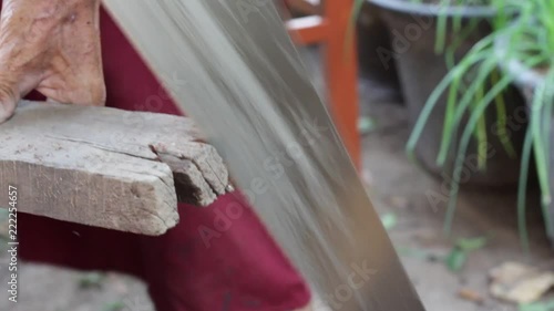 HD video footage showing an unrecognizable carpenter sawing a piece of wood with his metallic saw
